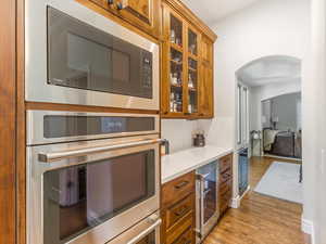 Kitchen with stainless steel microwave, new cabinets, double ovens, and glass insert cabinets