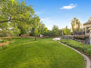 View of green lawn featuring a deck