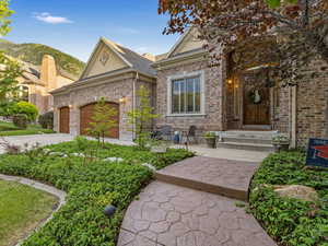 View of front of property with brick siding, an attached garage, driveway, and roof with shingles