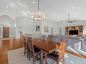 Dining nook with high vaulted ceiling, a chandelier, wood finished floors, and recessed lighting