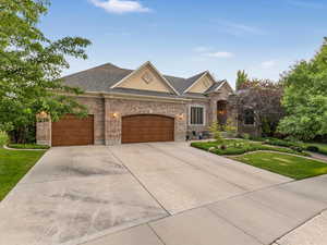 View of front of house featuring a new shingled roof, front yard, driveway, an attached garage, and brick exterior