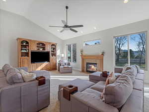 Carpeted living area featuring recessed lighting, vaulted ceiling, a tiled fireplace, and ceiling fan