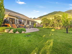 Back of house with a patio area, deck, a lawn