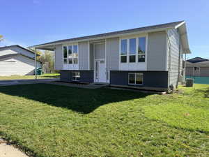 Raised ranch featuring a front lawn and brick siding