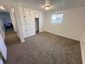 Unfurnished bedroom with dark colored carpet and a closet