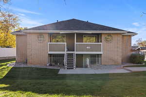 Front of house with stairway, brick , and a balcony