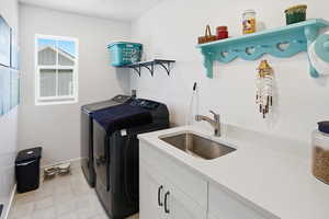Laundry Room featuring sink, shelves and cabinet space