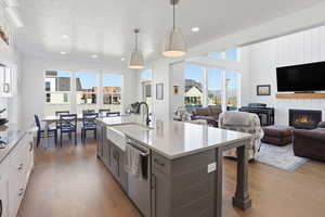 Kitchen with a center island with sink, open floor plan, decorative light fixtures, light wood-type flooring, and recessed lighting