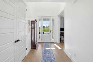 Entryway with light wood finished floors and baseboards