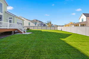 Fenced backyard featuring a residential view, a wooden deck, and stairway