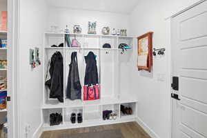 Mudroom featuring dark wood-style flooring and baseboards
