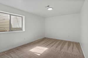 Carpeted empty room with baseboards