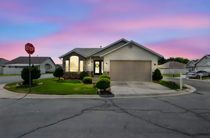 Ranch-style home featuring concrete driveway, a garage, and stone siding