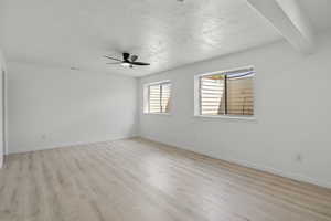 Spare room with light wood-style flooring, a ceiling fan, and a textured ceiling