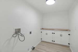 Washroom featuring hookup for a washing machine, light wood-type flooring, hookup for an electric dryer, and cabinet space