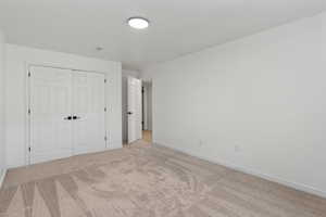 Unfurnished bedroom featuring carpet floors and a closet