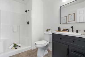 Bathroom featuring vanity, light tile patterned flooring, and a shower stall