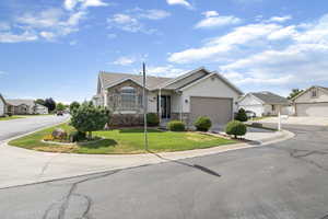 Ranch-style house featuring stone siding, a front lawn, a residential view, and driveway