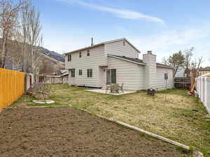 Back of property featuring a patio area, a fenced backyard, and a chimney