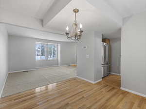 Spare room featuring suspended lighting and light wood finished floors