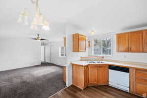 Kitchen featuring light countertops, dishwasher, dark wood-type flooring, a chandelier, and brown cabinets