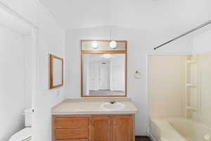 Full bath featuring vanity, shower / washtub combination, and vaulted ceiling