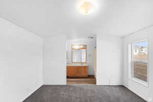 Unfurnished bedroom featuring carpet flooring and lofted ceiling