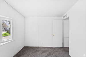 Unfurnished bedroom featuring dark colored carpet