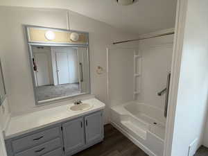 Bathroom with vanity,  shower combination, dark wood-type flooring, and a textured ceiling