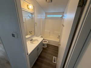 Full bathroom with vanity, bathtub / shower combination, and dark wood-style flooring