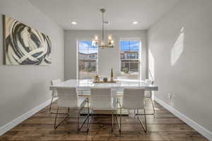Dining room featuring dark wood-style flooring, a chandelier, and recessed lighting