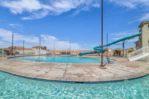 Community pool featuring a water slide and a patio