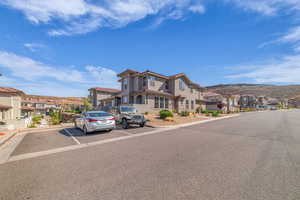 Mediterranean / spanish house featuring stucco siding, a tile roof, uncovered parking, and a residential view