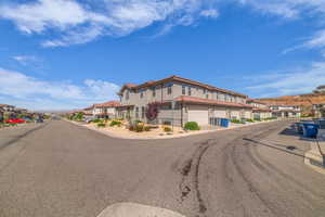 View of asphalt street featuring a residential view and curbs