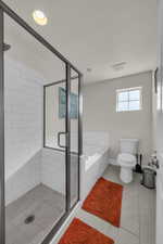 Bathroom featuring a garden tub, a stall shower, light tile patterned floors, and recessed lighting
