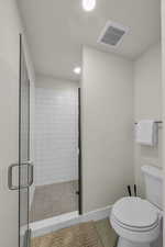 Full bath featuring a shower stall, tile patterned flooring, and recessed lighting