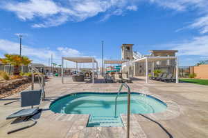 View of swimming pool with a patio area, a hot tub, and a swimming pool