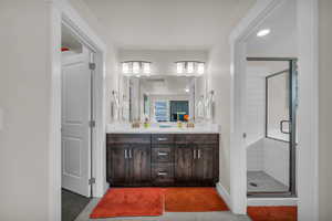 Full bath with a stall shower, double vanity, light tile patterned floors, and recessed lighting