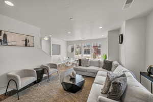 Living area with wood finished floors and recessed lighting