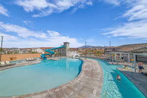 Community pool featuring a water slide, a patio, and a mountain view