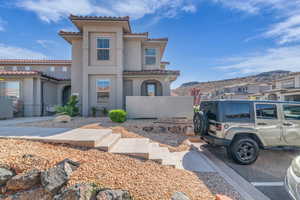 Mediterranean / spanish-style house featuring stucco siding, a mountain view, and a tile roof