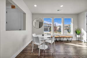 Dining space with dark wood-style flooring and recessed lighting