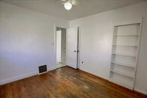 Unfurnished bedroom with dark wood-style floors and ceiling fan