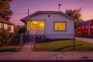 Bungalow-style home with a gate, a fenced front yard, and cooling unit