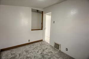 Unfurnished room featuring carpet floors and baseboards