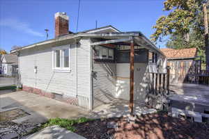 Back of house featuring crawl space and a chimney