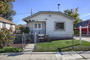 View of front facade with a gate, a fenced front yard, covered porch, and cooling unit