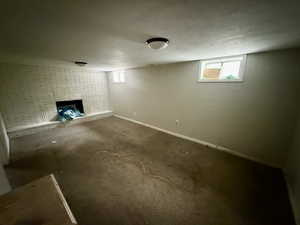 Basement featuring carpet floors and a brick fireplace