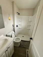 Full bathroom with dark wood-type flooring, vanity, and a stall shower
