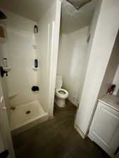 Full bathroom featuring dark wood-type flooring, vanity, and a stall shower